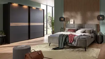 Ein modern eingerichtetes Schlafzimmer mit einem grauen Polsterbett